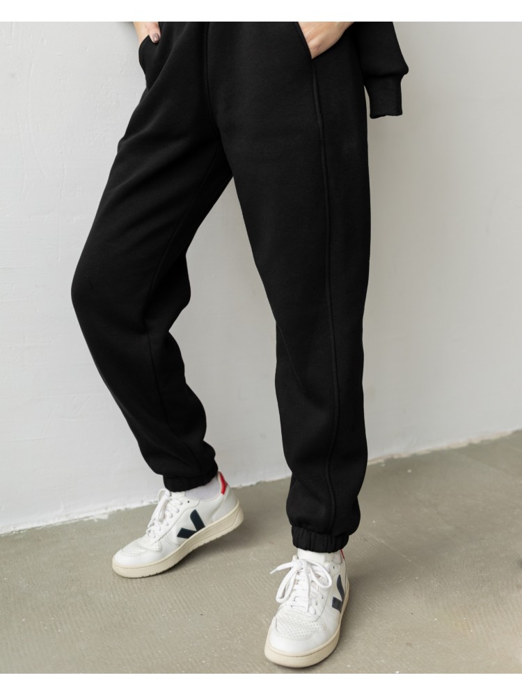 Спортивні штани з завищеною талією та з косими кишенями у чорному кольорі. Трикотажний спортивний костюм