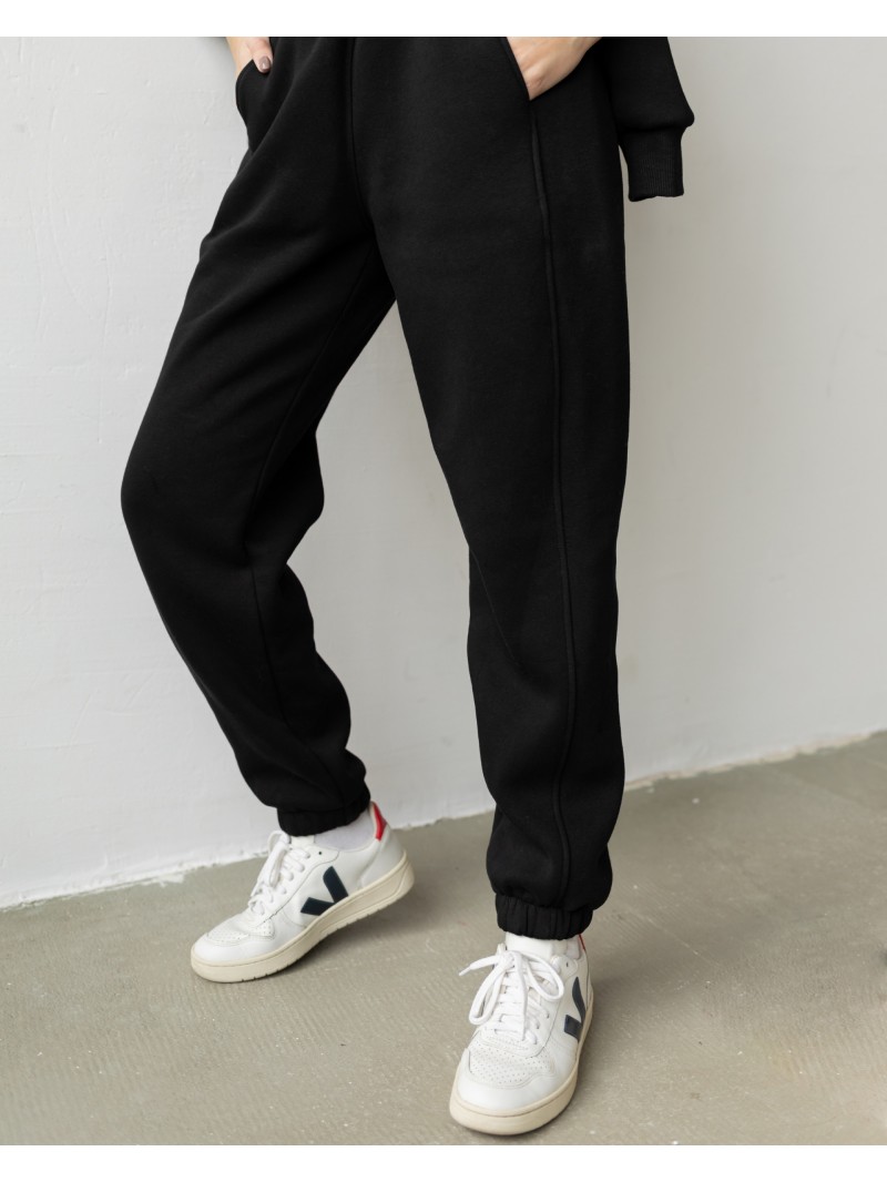 Спортивні штани з завищеною талією та з косими кишенями у чорному кольорі. Трикотажний спортивний костюм