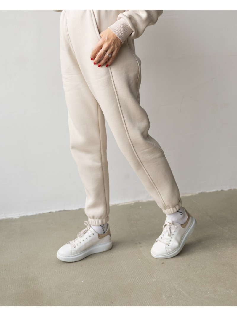 Спортивні штани з завищеною талією та з косими кишенями у бежевому кольорі. Трикотажний спортивний костюм